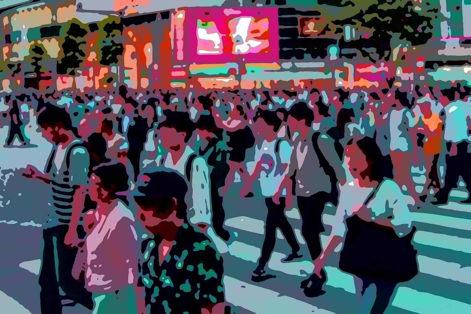 A large crowd of people is crossing a city street at a busy intersection, with illuminated billboards and buildings visible in the background.