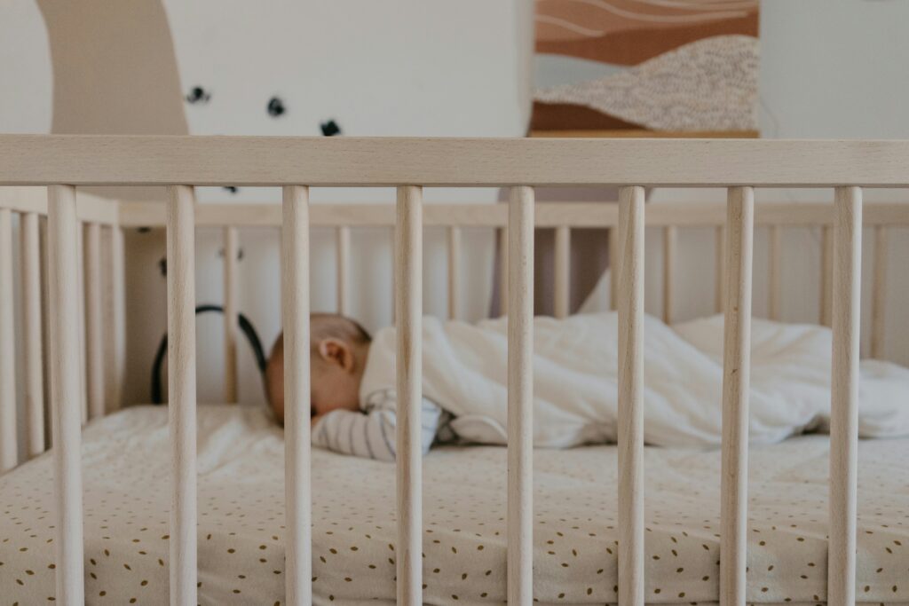 Sleeping baby in white crib.